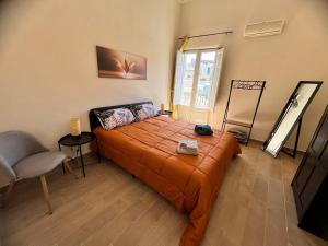 een slaapkamer met een bed met een oranje sprei bij La dimora di Silvio in Catania