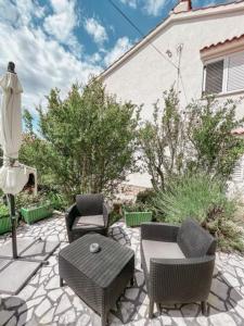 a patio with chairs and a table and an umbrella at Apartman Ponte Martini in Punat