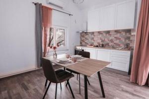 a kitchen with a wooden table and chairs in a room at Apartman Ponte Martini in Punat