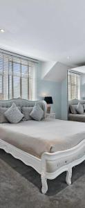 sypialnia z dużym białym łóżkiem z poduszkami w obiekcie Hampstead Opulence Apartment - Luxurious Split Level Property w Londynie