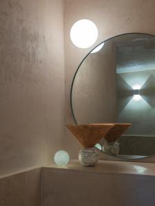 a mirror on top of a shelf in a room at LABottega - Camere in Marina di Pietrasanta