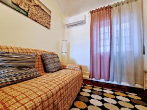 um quarto com uma cama e uma janela com cortinas em Casa d'Alfama by Lisbon Village Apartments em Lisboa