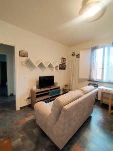 a living room with a couch and a television at Casa Moki in Uliveto Terme