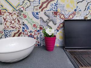 a bathroom with a toilet and a flower in a pink cup at CasAnna in Castellammare del Golfo +57 photos