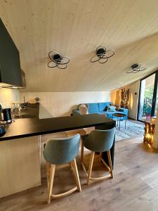 a kitchen and living room with a counter and chairs at Apartmán Tri Smreky Demänovská Dolina in Belá