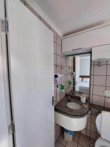 y baño con lavabo, aseo y espejo. en diRoma Fiori 89 com roupa de cama e banho. en Caldas Novas