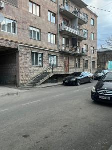two cars parked in front of a brick building at S-Nova in Gyumri