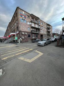 an empty street with cars parked in front of a building at S-Nova in Gyumri