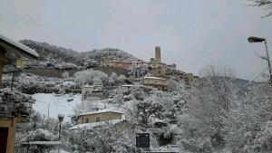 a snow covered hill with houses on a mountain at CASA ALICE in Poggio Catino