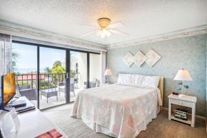 1 dormitorio con 1 cama y balcón en Land's End 1-307 Gulf View, en St Pete Beach