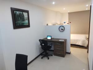 a room with a desk and a bed and a clock at Casa Almendro in Chía