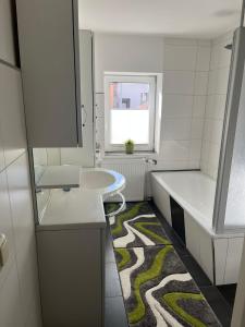 a white bathroom with a sink and a tub at Perle im Zentrum in Eschwege