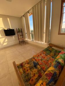 a living room with a couch with a flower blanket at Casa da Vista - LAGOA SANTA in Lagoa Santa