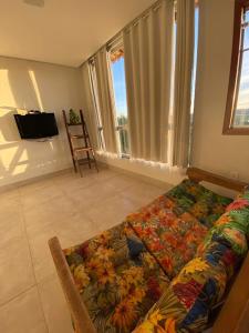 uma sala de estar com um sofá com um cobertor de flores em Casa da Vista - LAGOA SANTA em Lagoa Santa