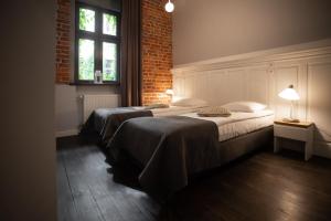 um quarto com 2 camas e uma parede de tijolos em Apartament Atłasowy by Good Time em Lódź