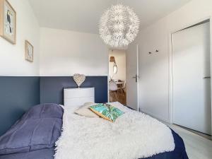a bedroom with a bed and a chandelier at Maison cosy calme CARQUEFOU parking inclus in Carquefou