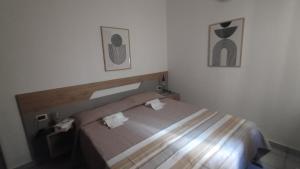a bedroom with a bed and two pictures on the wall at LechicchediLampedusa in Lampedusa