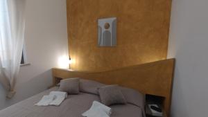 a bedroom with a bed with a wooden head board at LechicchediLampedusa in Lampedusa