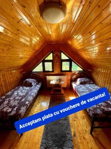 Habitación con 2 camas en una cabaña de madera en Vila Maria Dambovicioara, en Dîmbovicioara