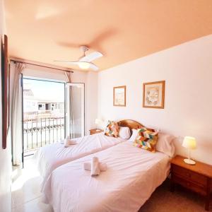 Apartamentos Vicenta Playa Carihuela في توريمولينوس: سريرين في غرفة نوم مع شرفة