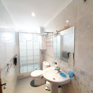 a bathroom with a sink and a toilet and a mirror at Apartamentos Vicenta Playa Carihuela in Torremolinos