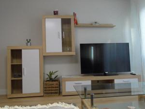 a living room with a flat screen tv and shelves at INSULA PLAzA MAYOR HOME in Astorga
