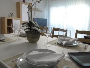 uma mesa com copos de vinho e um prato em INSULA PLAzA MAYOR HOME em Astorga