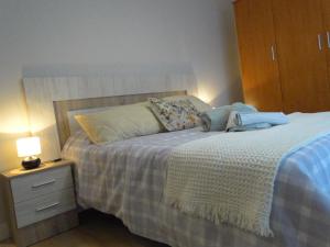 1 dormitorio con 1 cama y mesita de noche con lámpara en INSULA PLAzA MAYOR HOME en Astorga