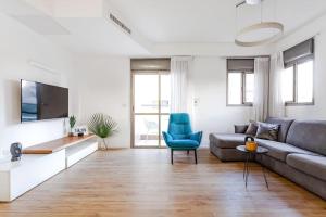 ein Wohnzimmer mit einem Sofa und einem TV in der Unterkunft One Step from the Sea. Apartment 5 +parking. in Tel Aviv