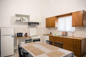 a kitchen with a table and a white refrigerator at Konstantina's Fairytale House in Kissamos