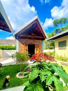 uma pequena casa de tijolos com um quintal com plantas em Abrolhos Dive Inn em Caravelas