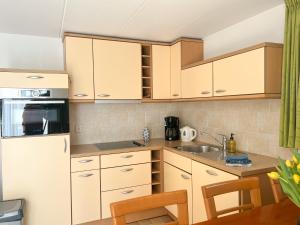 a kitchen with white cabinets and a sink at Gelijkvloers Vakantieappartement 150m van Strand Egmond aan Zee in Egmond aan Zee +27 photos