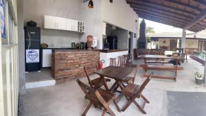 a patio with wooden tables and chairs and a counter at Abrolhos Dive Inn in Caravelas