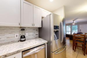 a kitchen with white cabinets and a stainless steel refrigerator at Golden Oasis, Unit #110 in Scottsdale