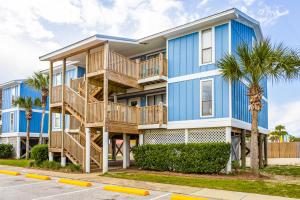 een blauw appartementencomplex met palmbomen ervoor bij Seahorse 122 in Gulf Shores