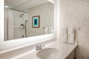 a white bathroom with a sink and a mirror at Crowne Plaza Indianapolis-Airport, an IHG Hotel in Indianapolis