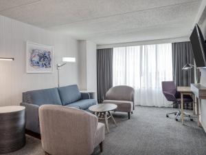 sala de estar con sofá azul y sillas en Crowne Plaza Indianapolis-Airport, an IHG Hotel en Indianápolis