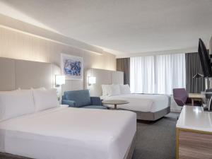 Habitación de hotel con 2 camas y sofá en Crowne Plaza Indianapolis-Airport, an IHG Hotel en Indianápolis