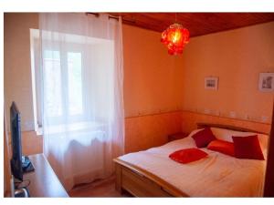 1 dormitorio con 1 cama con ventana y lámpara de araña en La Réclot, en Herran