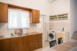 a kitchen with a sink and a washing machine at Konstantina's Fairytale House in Kissamos