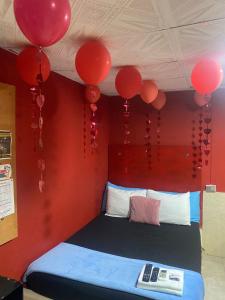 a room with a bed with red balloons on the ceiling at Hotel la Sierra Riohacha I in Ríohacha