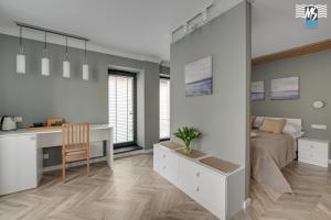 a bedroom with a bed and a desk and a desk at MS Apartments Rest 3.0 in Sopot
