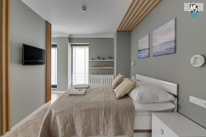 1 dormitorio con 1 cama grande y espejo en MS Apartments Rest 3.0 en Sopot
