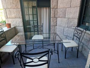 szklany stół i krzesła na patio w obiekcie Hostal O Galeón San Luis w mieście Moaña