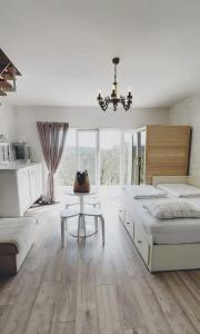 a bedroom with two beds and a table and a chandelier at House with hot tub, sauna and swimming pool near Zagreb in Gudci