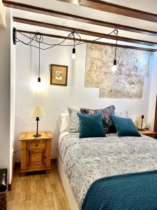 um quarto com uma cama com almofadas azuis em Apart. Entrepatios em Toledo