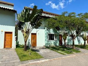 una casa con dos puertas marrones y algunos árboles en Casa Clean e Comfort, a mais completa de Paúba, en São Sebastião