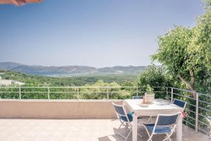 a white table and chairs on a balcony with a view at Konstantina's Fairytale House in Kissamos