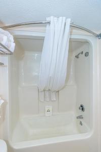 uma banheira branca com uma cortina de chuveiro branca em Sun N Sand 607 em Myrtle Beach