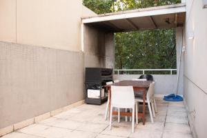d'une terrasse avec une table, des chaises et une télévision. dans l'établissement * Grand Oro *, à Buenos Aires